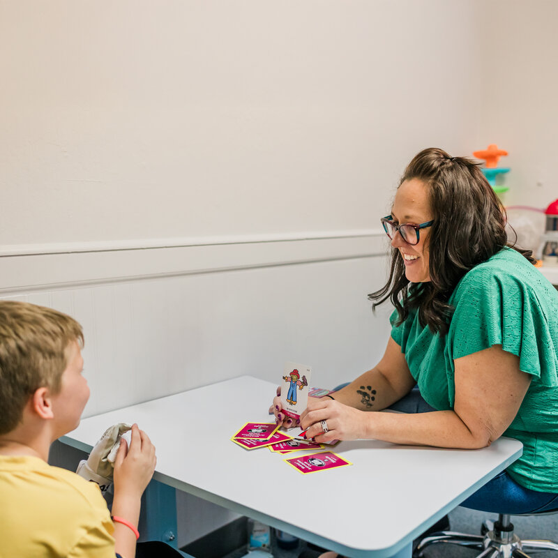 Speech therapist helping a child build language skills through interactive activities